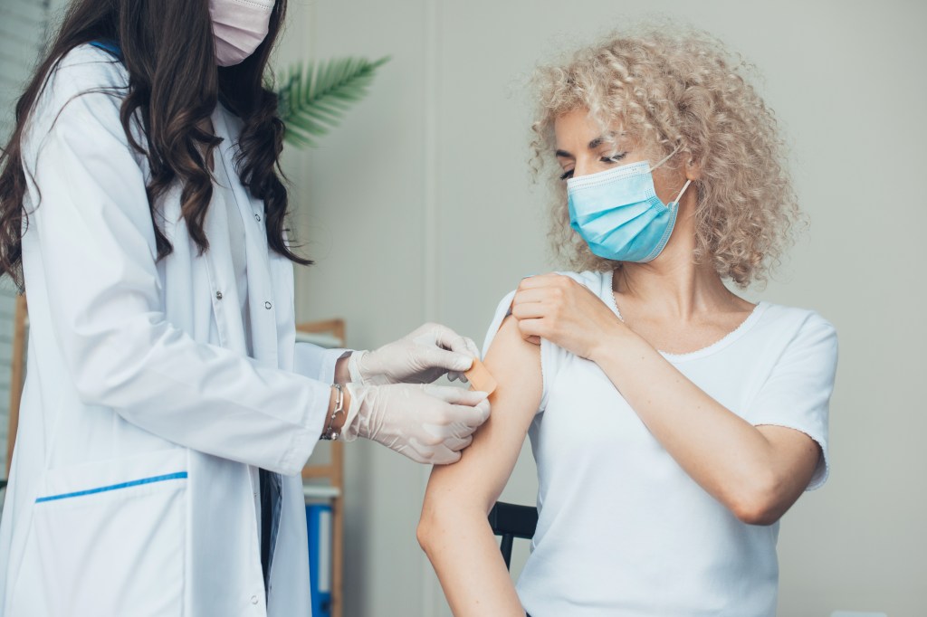 A woman receives a vaccine. 
